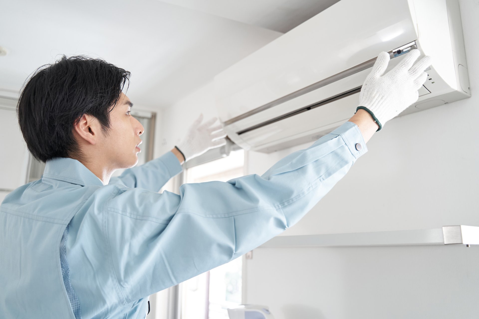 家庭用の壁掛けエアコンを分解して内部を洗浄している作業風景